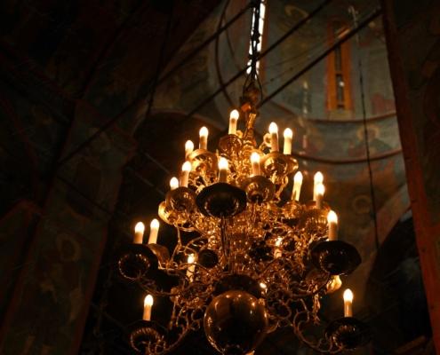 Lampadario a candele dorato appeso sotto la cupola affrescata della Chiesa del Salvatore sul Sangue Versato