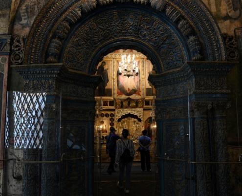 Dettaglio del monumentale portale interno in pietra blu con decorazioni dorate e icone nel Cremlino